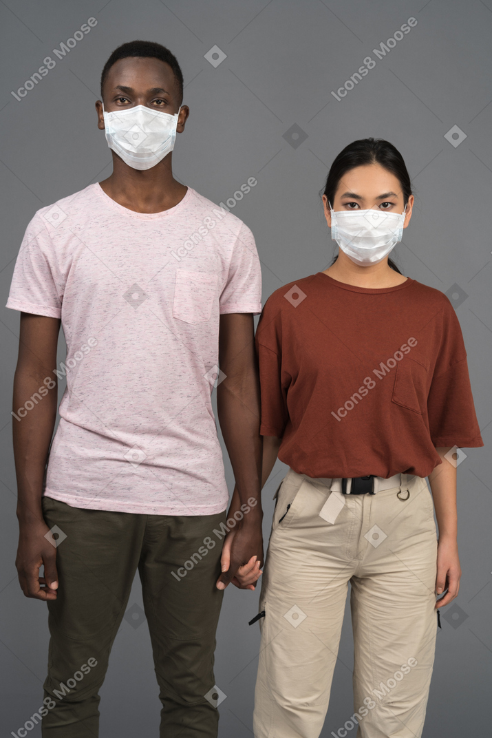 Una giovane coppia che indossa maschere per il viso