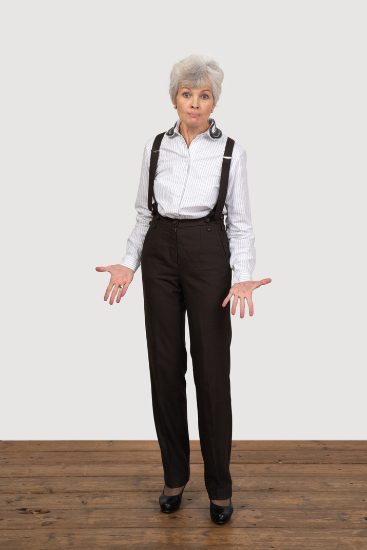 Front view of a gesticulating questioning old lady in office clothing