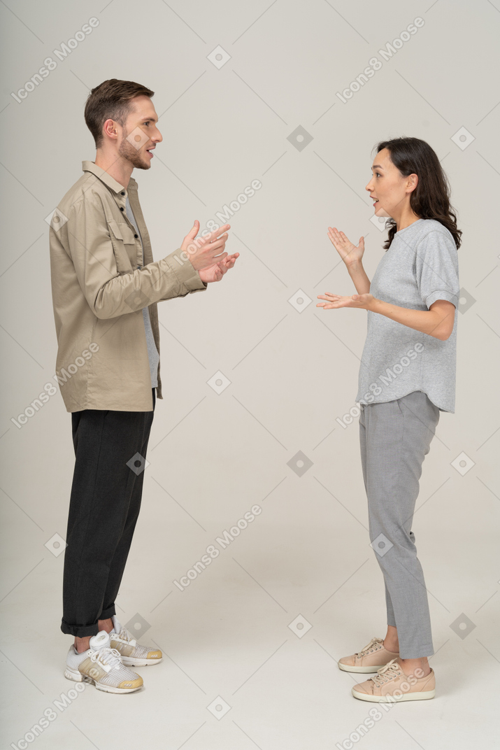 Vista lateral do jovem casal falando um com o outro