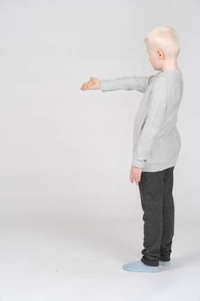 Side view of a boy holding out his hand