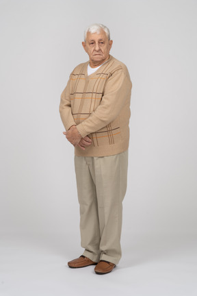 Front view of an old man in casual clothes looking at camera