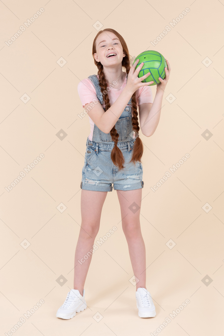 Teenage girl with her eyes closed holding ball