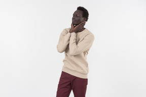 A young black man in a grey sweater standing alone on the white background