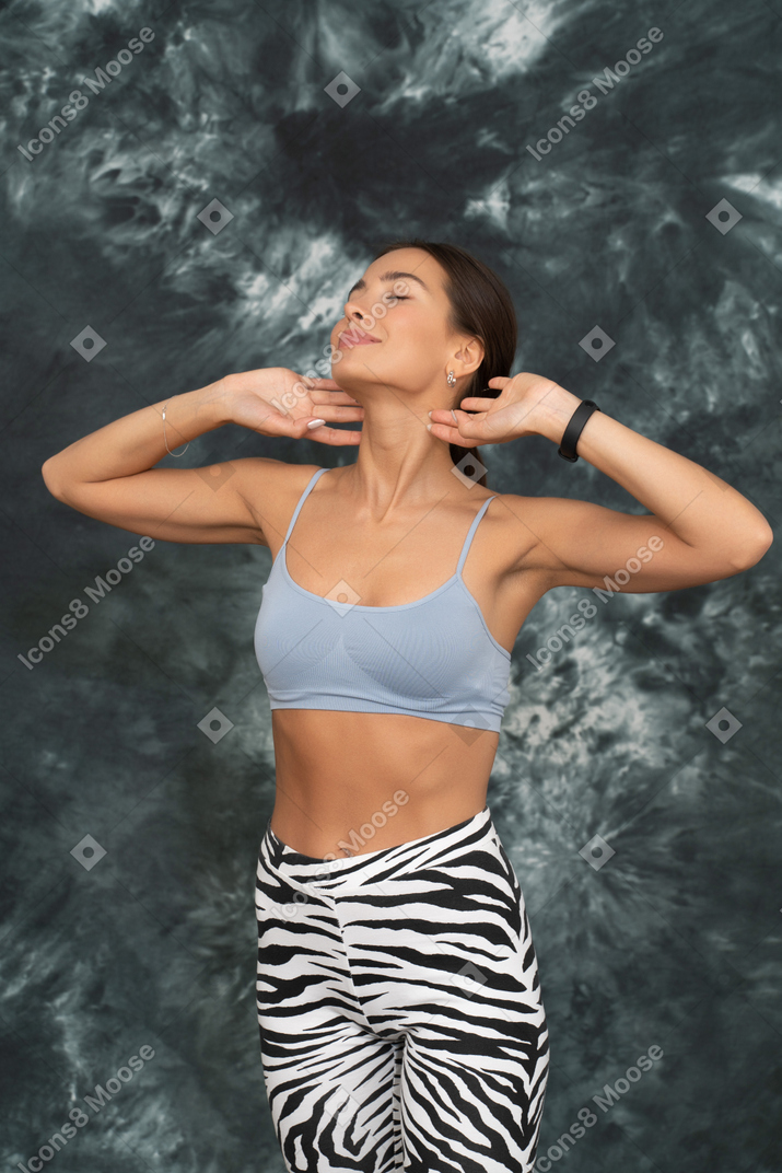 Pleased female athlete raising her hands and stretching