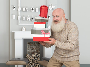 Белый бородатый мужчина приносит рождественские подарки