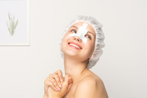 Smiling young woman with bandage on her nose after rhinoplasty