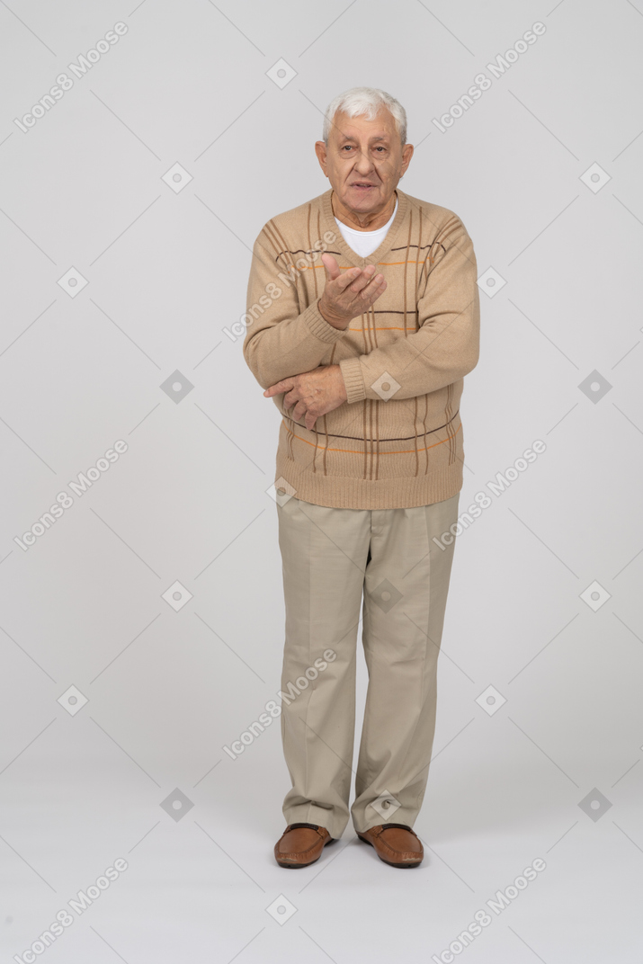 Vista frontale di un vecchio in abiti casual che spiega qualcosa