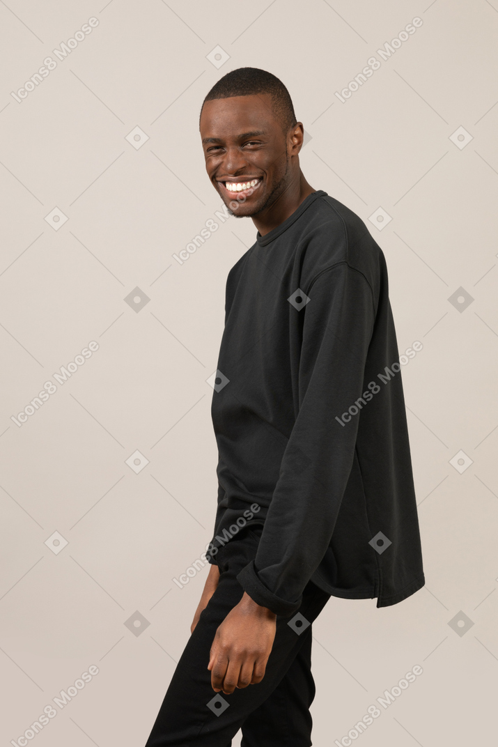 Side view of man looking at camera and laughing