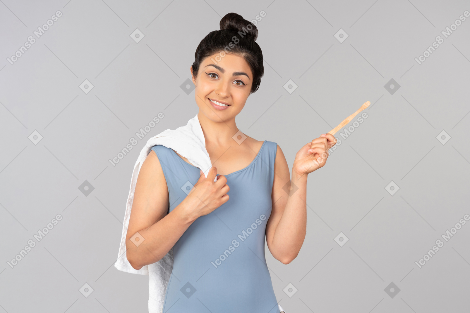 Young indian woman holding white towel and tooth brush