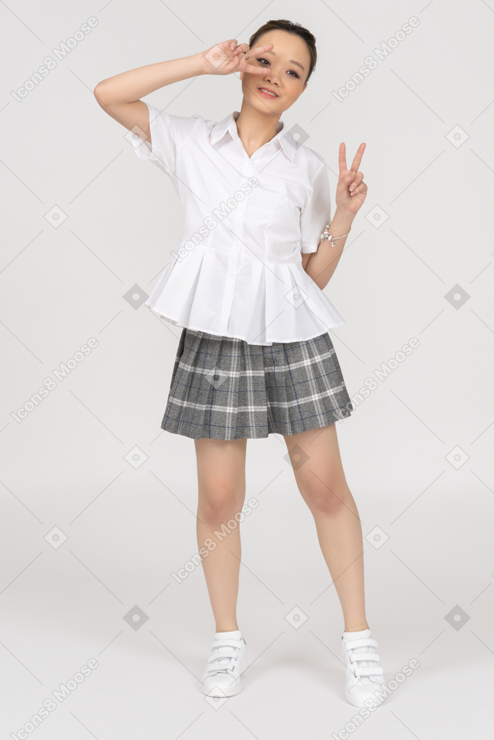 Cute asian girl making a victory gesture