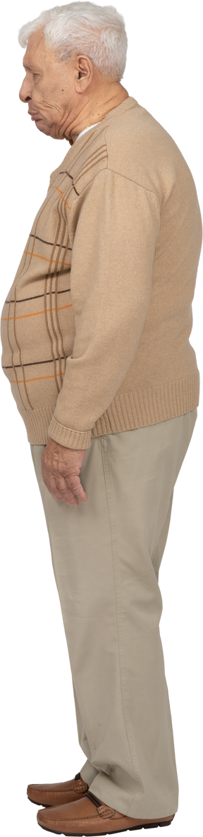 Vista lateral de un anciano con ropa informal haciendo muecas