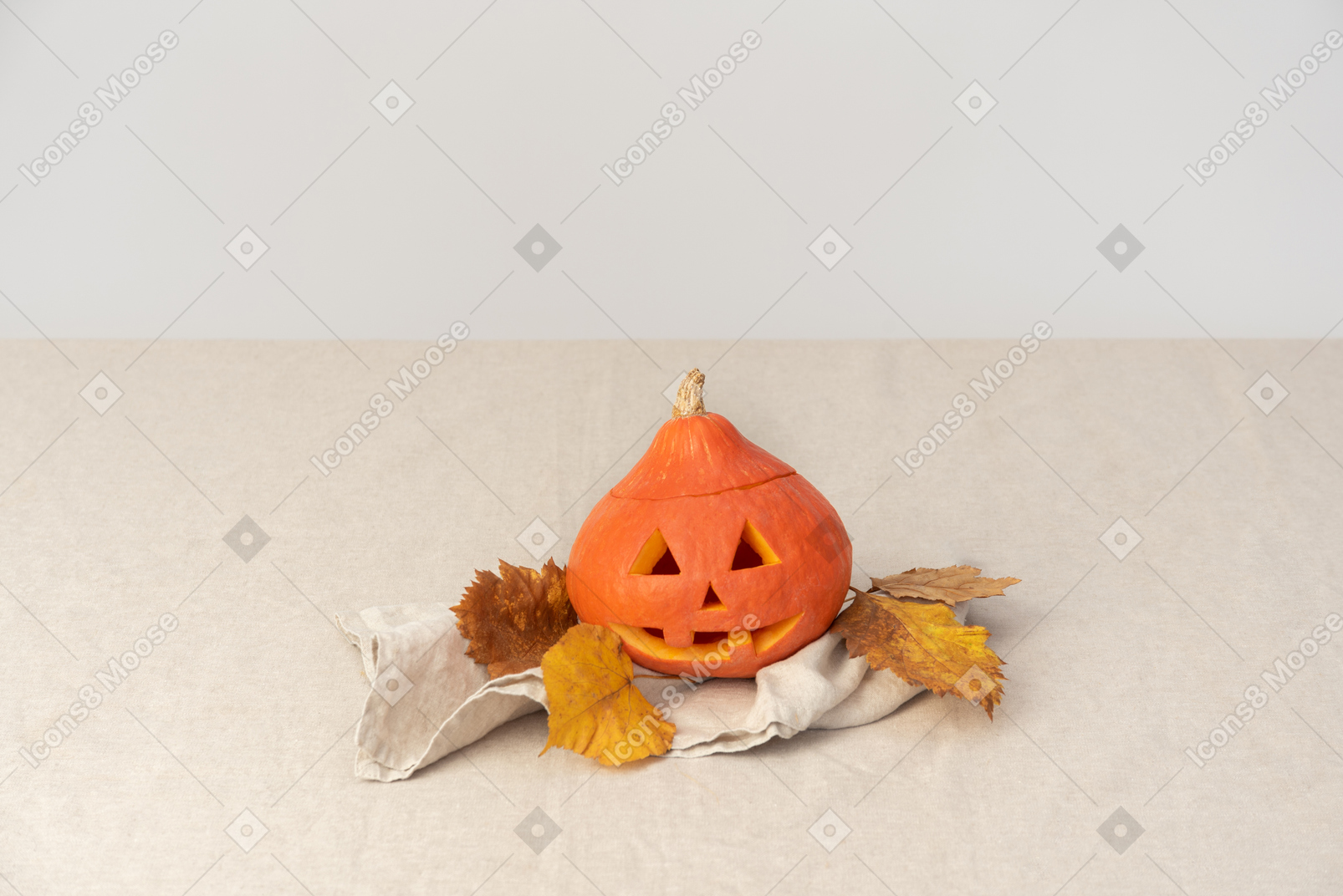 Carved pumpkin and yellow leaves