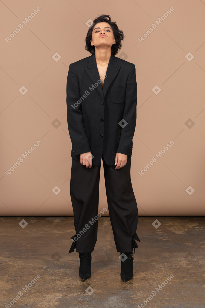 Front view of a  pouting businesswoman in a black suit throwing head back and looking at camera