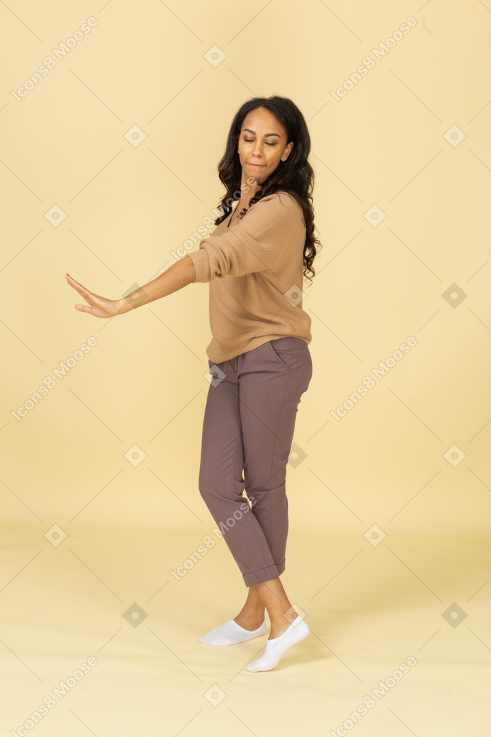 Трехчетвертный вид невольной темнокожей молодой женщины, протягивающей руку