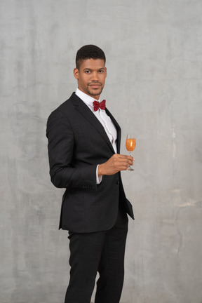 Well-dressed young man holding a champagne glass