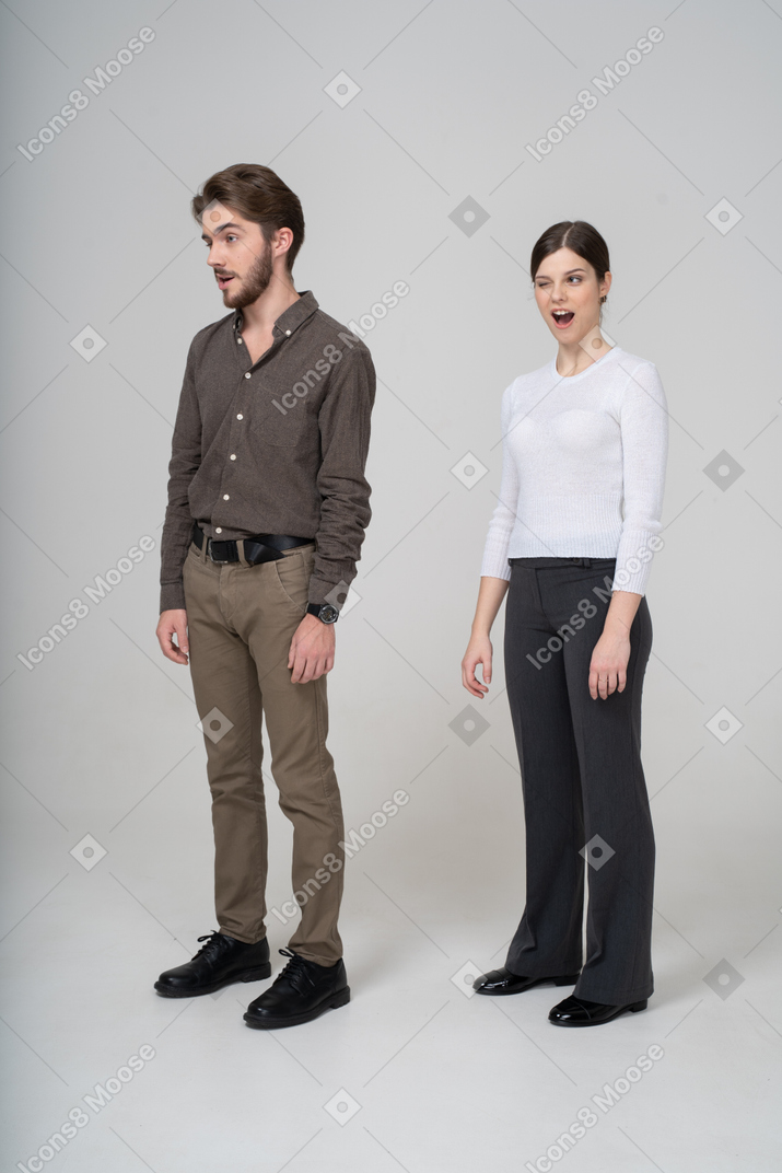 眨眼的年轻夫妇，在办公室服装中的四分之三的视图