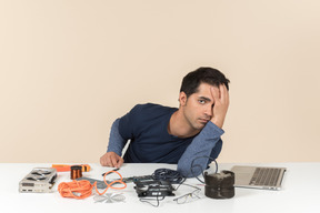 A young man in casual blue clothes working with computer details