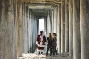 Two women talking to santa claus on the beach