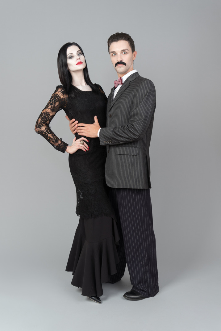 Morticia and gomez addams standing next to each other