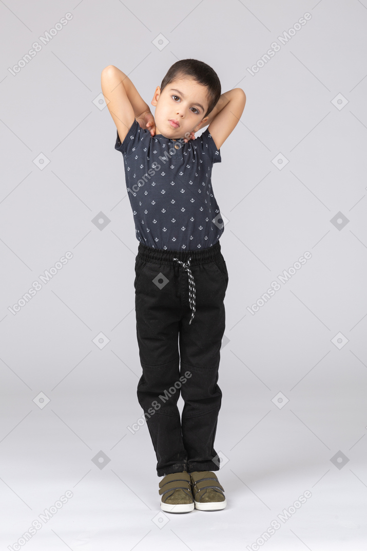 Front view of a cute boy posing with hands behind head