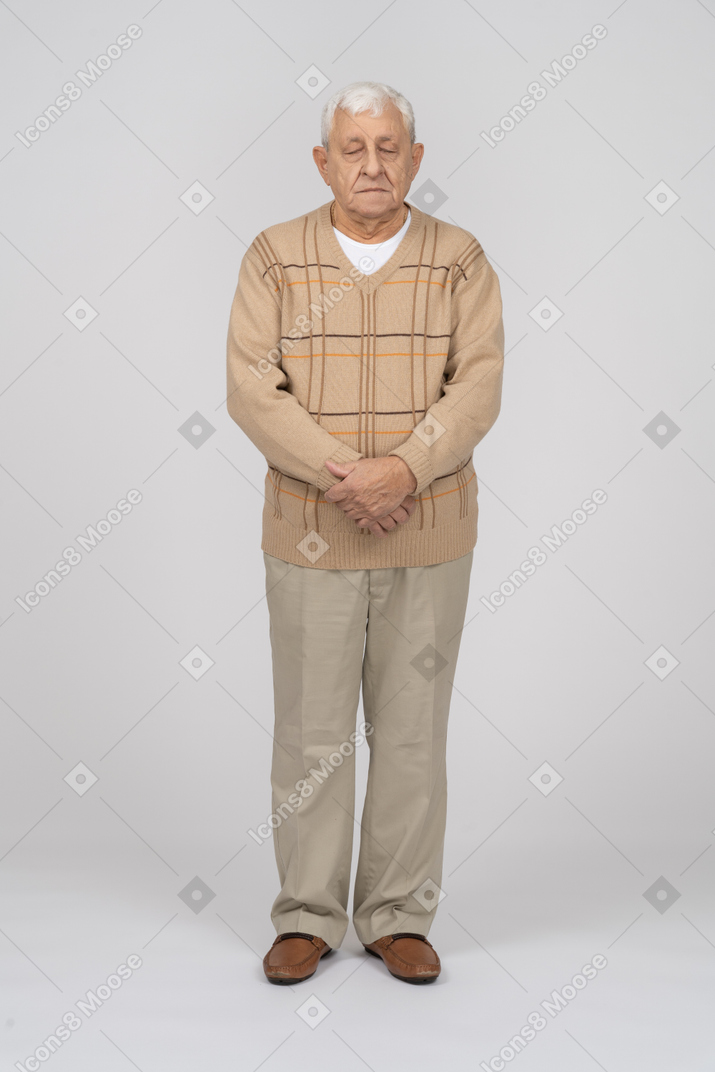 Vista frontale di un vecchio in abiti casual in piedi con le mani incrociate