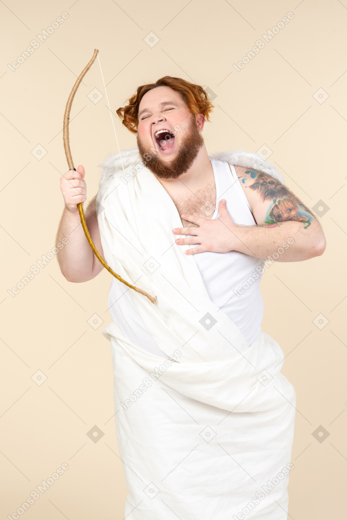 Laughing big guy dressed as a cupid holding bow