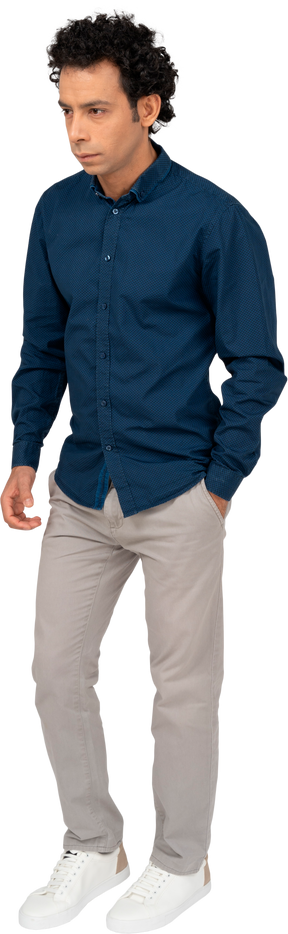 Vista frontal de um homem em roupas casuais em pé com a mão no bolso