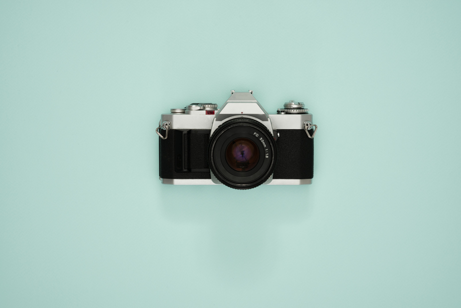 Vintage photo camera on a turquoise background