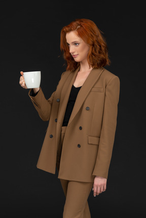 Молодая деловая женщина держит кружку кофе