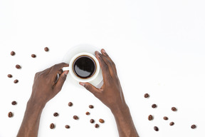 Schwarze männliche hände, die tasse schwarzen kaffee halten