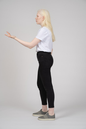 Vista laterale di una giovane donna in piedi e braccio di estensione