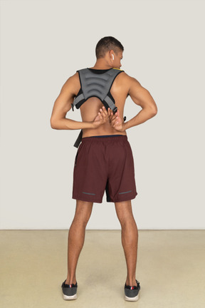 Back view of man adjusting weighted vest