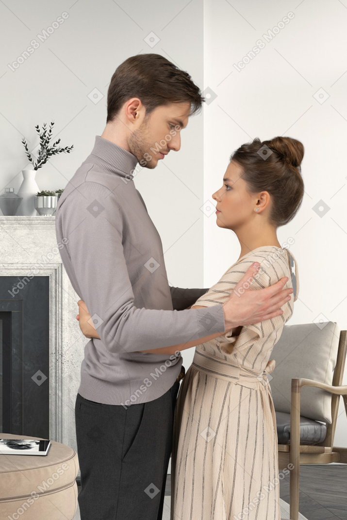 A man and a woman holding each other in a living room