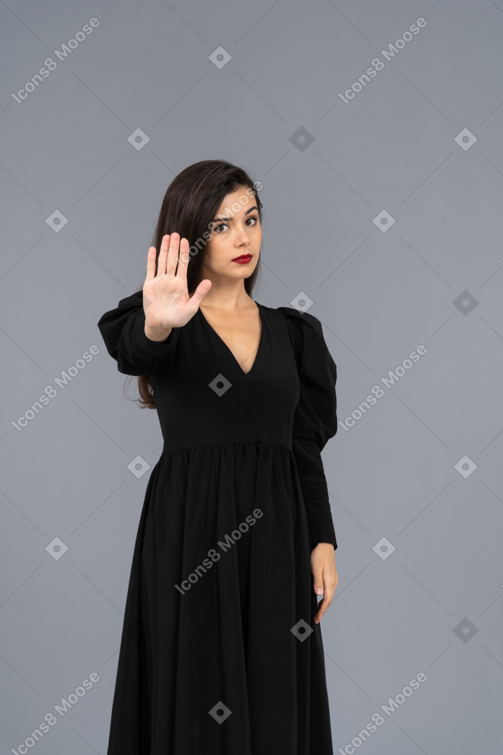 Front view of a young lady in a black dress raising her hand