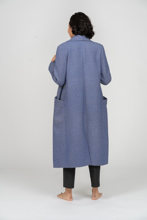 Vista traseira de uma mulher ajustando seu casaco