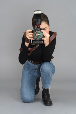 Mujer poniéndose de rodillas para tomar una foto