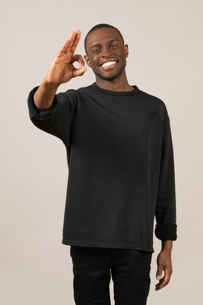 Smiling young man showing ok sign