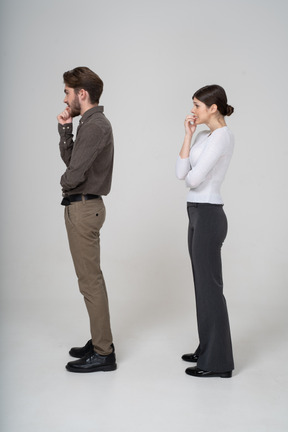 Side view of a nervous young couple in office clothing touching chin