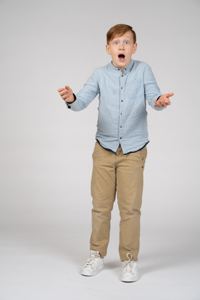 Front view of an impressed boy with open mouth looking at camera