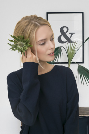 A woman with a plant in her hair