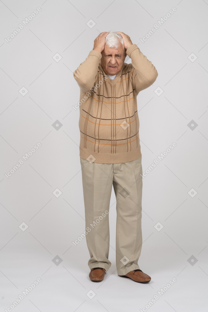 두통으로 고통받는 평상복을 입은 노인의 전면 모습