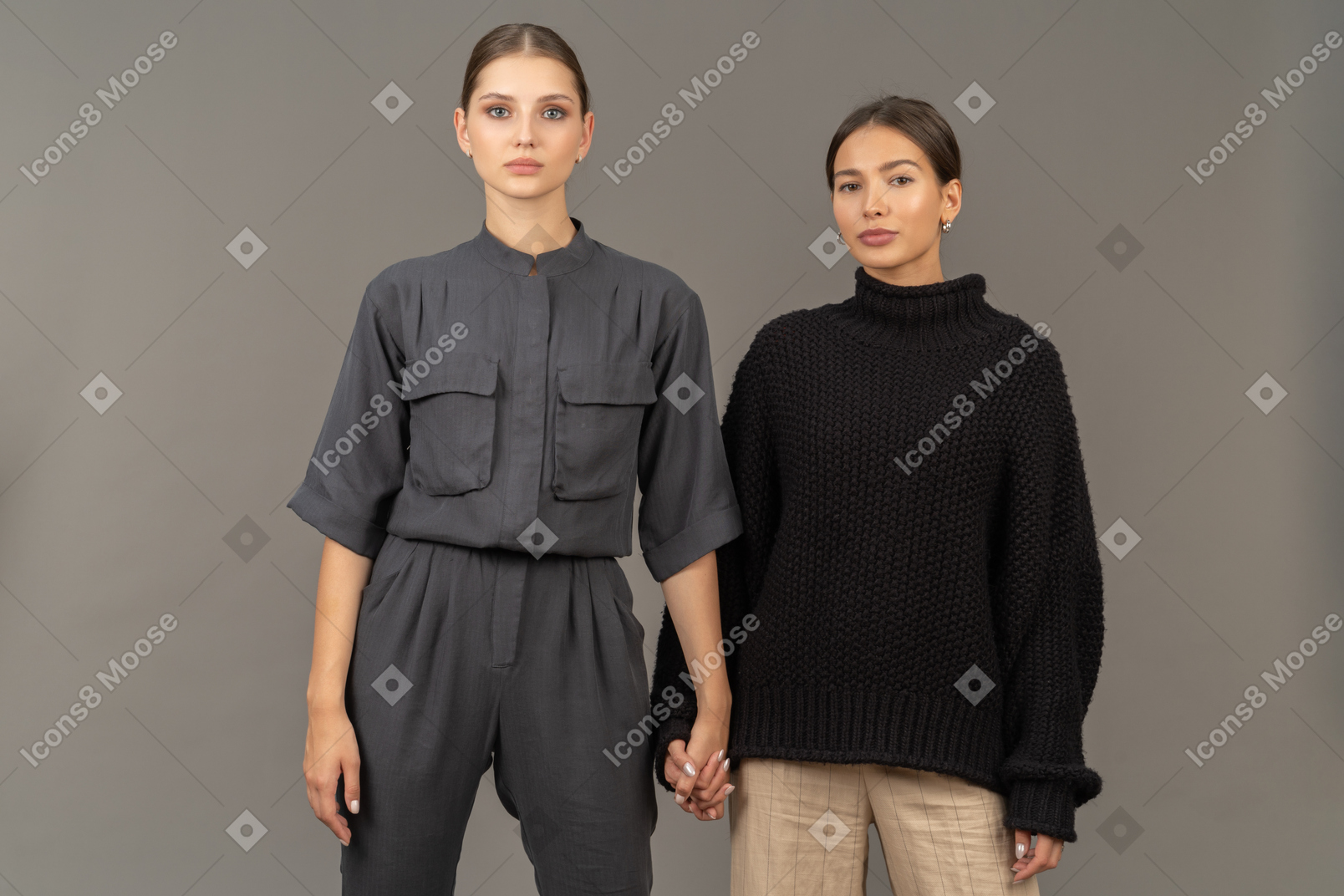 Two women holding hands and looking at camera