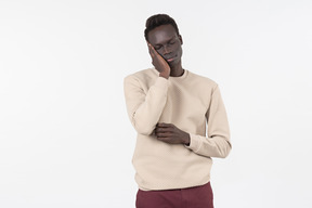 A young black man in a grey sweater standing alone on the white background