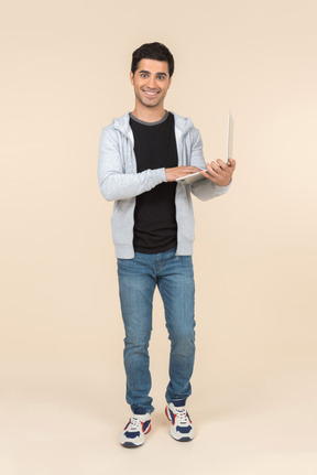 Young caucasian man holding laptop