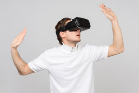 Jeune homme dans un casque de réalité virtuelle explorant le monde numérique