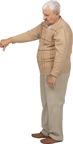 Side view of an old man in casual clothes showing thumb down