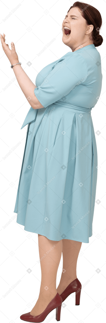 Vista lateral de uma mulher de vestido azul bocejando
