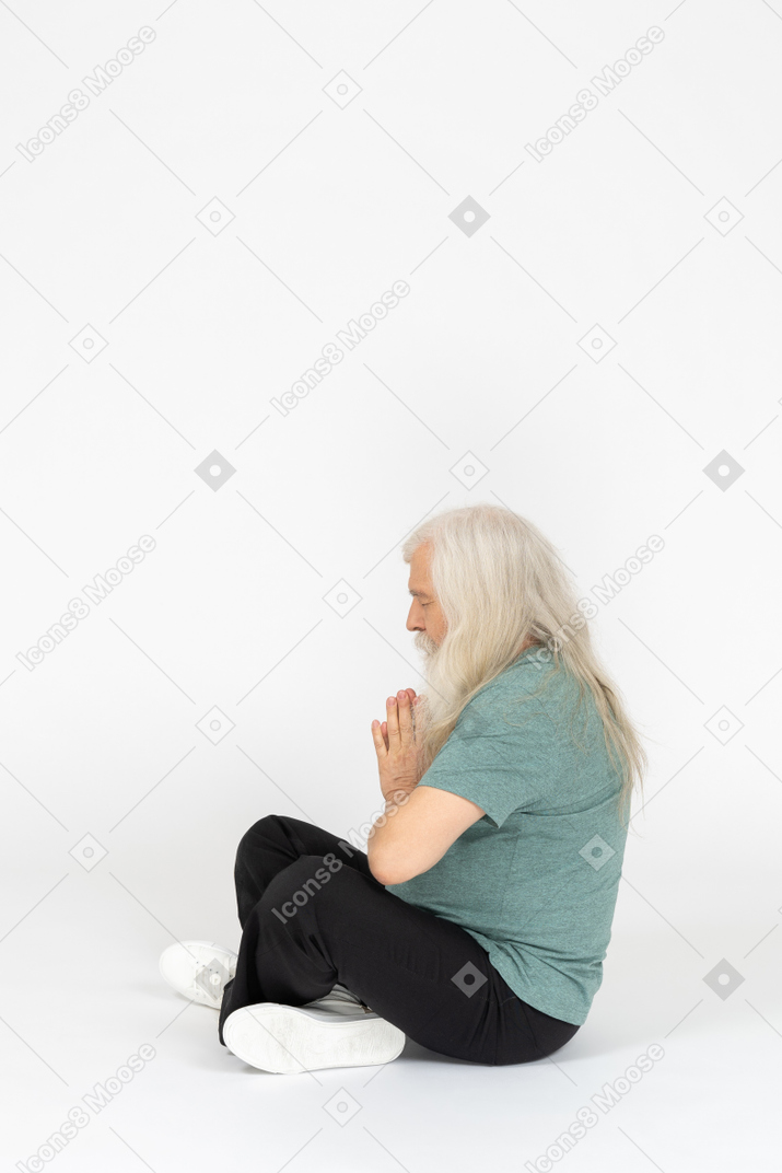 Vista lateral del anciano rezando