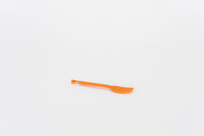 Plastic orange fork on a white background