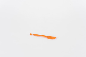 Fourchette en plastique orange sur fond blanc